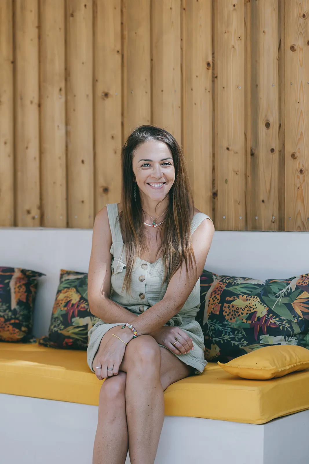 Charlotte Marco architecte d'intérieur à Montpellier assise sur une banquette jaune