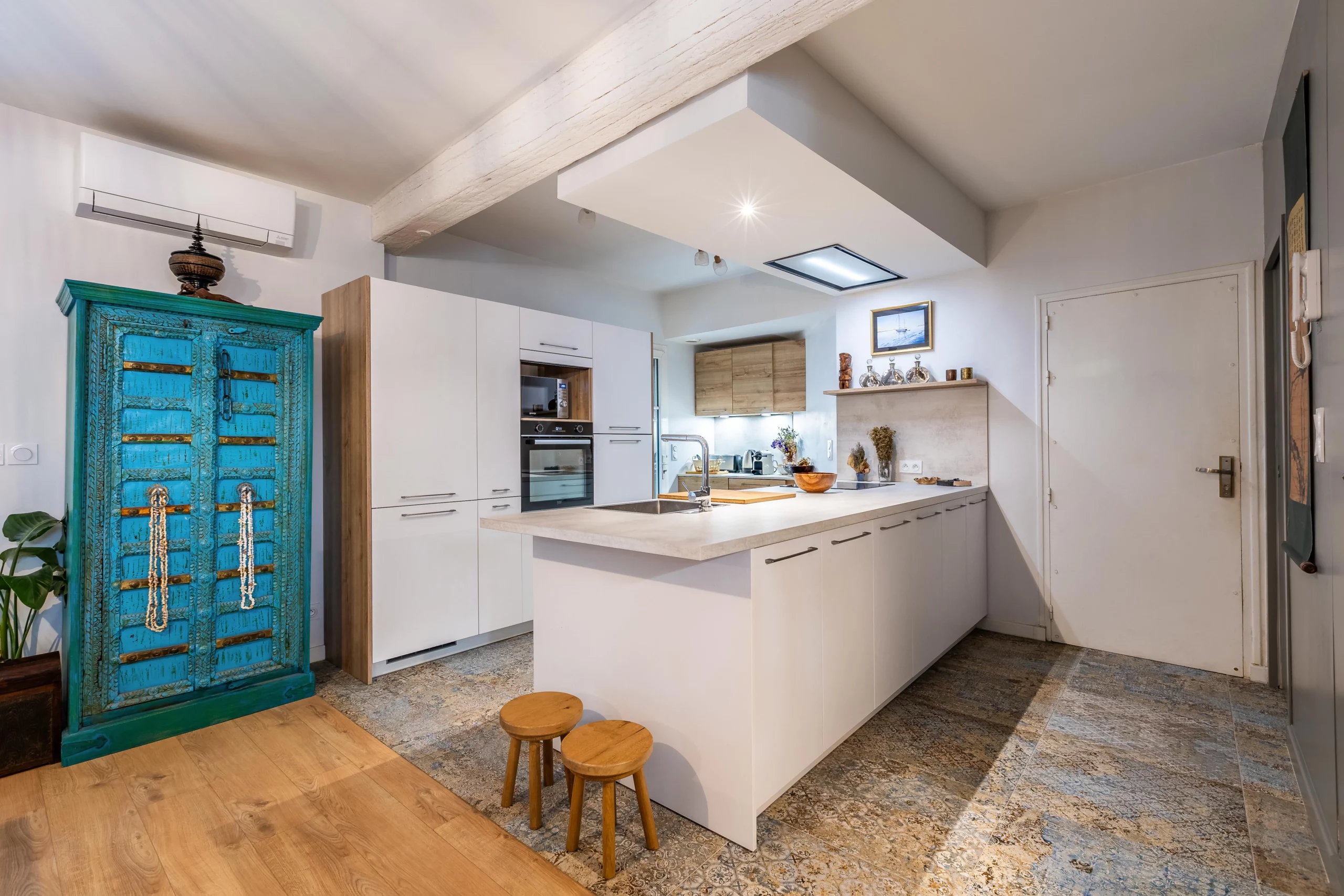 Cuisine blanche avec armoire indienne turquoise et carrelage patiné réalisée par une architecte d'intérieur à Montpellier